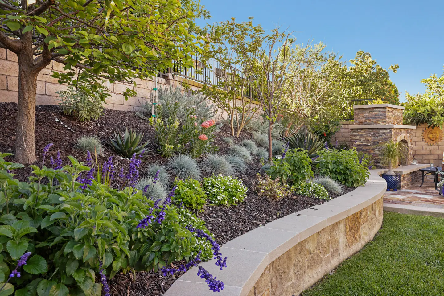 Stone retaining wall with landscaped planting bed